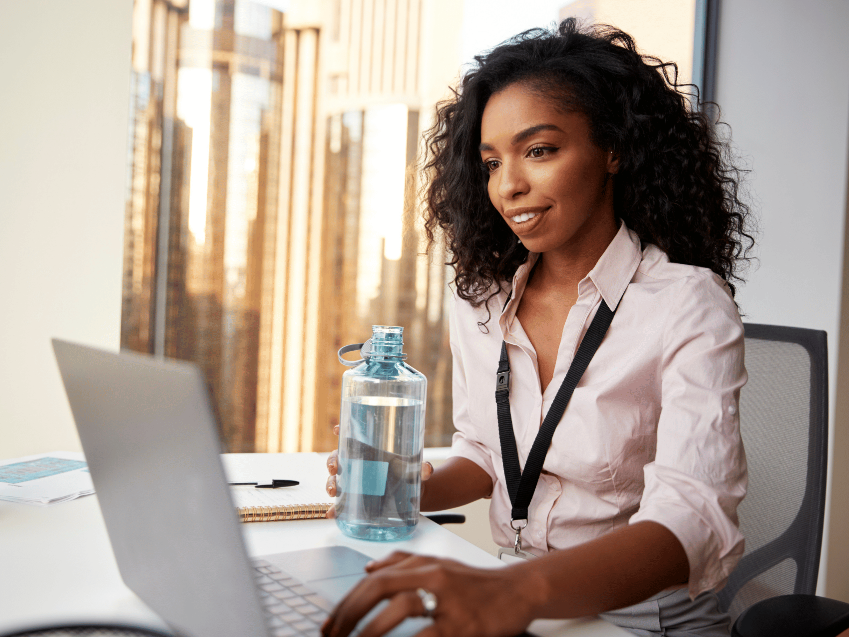 Hydration and Energy – glass of water next to a laptop on a desk